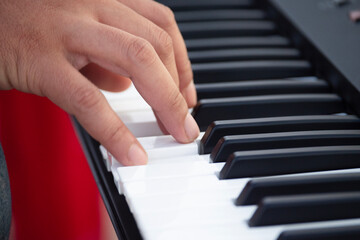 Fototapeta premium hands of a child playing the piano,Close-up of a musician's hands playing a piano or keyboard.