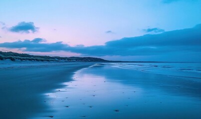 Serene beach at dusk with calm waters and gentle clouds.