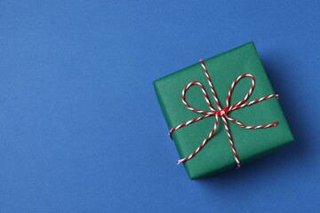 Beautiful gift box tied with bow on color background 