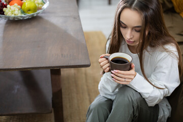 Enjoying a Cozy Morning Moment with a Steaming Mug of Coffee and Thoughtful Contemplation