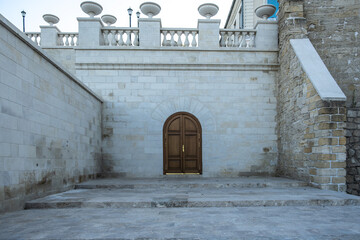 A wooden door in a stone wall on the street.