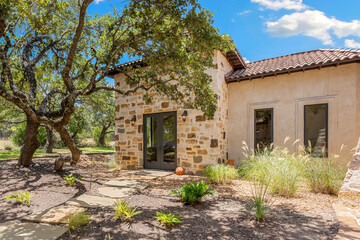 Beautiful stone cottage surrounded by lush greenery and blue skies