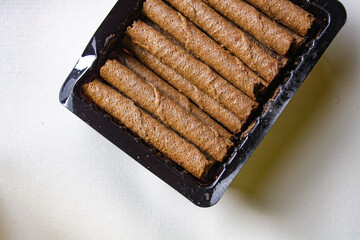 Chocolate wafer rolls in a plastic packaging on white background
