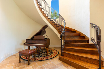 Elegant staircase with grand piano in spacious entryway
