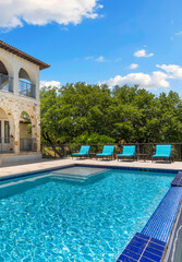 Elegant outdoor pool at a scenic villa under a bright blue sky