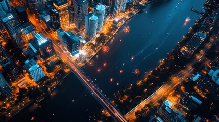 Fototapeta premium Aerial view of a vibrant cityscape at night, showcasing a river and illuminated buildings.