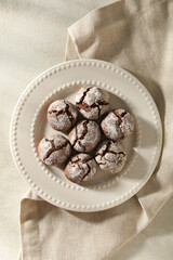 Delicious crinkle cookies in a plate, on a light background.