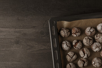 Appetizing crinkle cookies, on parchment, on a dark background.