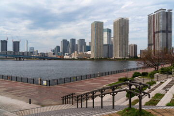 Obraz premium View of the Harumiohashi Bridge and district of Chuo Harumi from the Tokyo Bay Waterfront in Toyosu Park, Tokyo, Japan