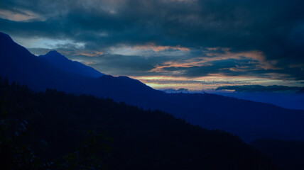 A Beautiful and Serene Mountain View at Dusk, Enveloped by Dramatic Clouds in the Sky