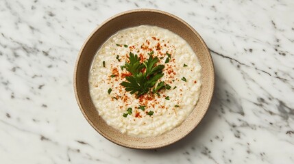 Creamy rice dish served in a rustic bowl, garnished with fresh herbs and spices on a marble countertop, perfect for comfort food lovers and culinary enthusiasts.