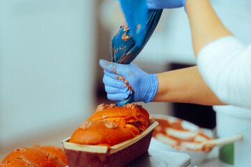 Confectioner Filling the Cakes with Chocolate Cream. Professional pastry chef preparing sweet bread specialties  
