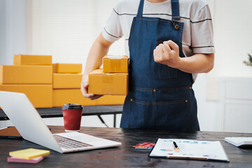 Close-up of a businessman’s hand packing items at a desk, preparing products for shipping. Highlighting delivery services for private companies online shopping with credit cards for convenience