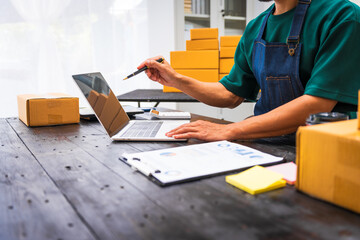 Close-up of a businessman’s hand packing items at a desk, preparing products for shipping. Highlighting delivery services for private companies online shopping with credit cards for convenience