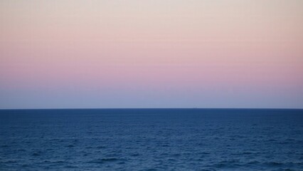 Obraz premium Serene Sunset Over Calm Blue Ocean: Capture the Beauty of Nature's Twilight