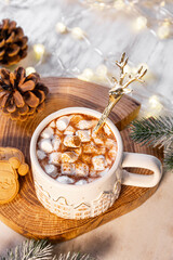 A mug of cocoa with marshmallows on a New Year's table on a white background. festive and cozy Christmas vertical card