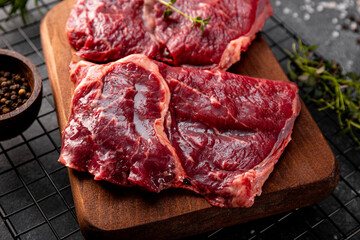 Raw beef chops on a cutting board. Animal product, red meat close up