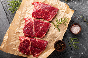 Raw beef chops on a cutting board. Animal product, red meat top view