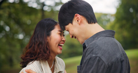 Fototapeta premium Happy couple laugh, love and forehead touch outdoor for loyalty, funny or support together. Japanese man, woman and romantic relationship at park for connection, care or trust on valentines day date