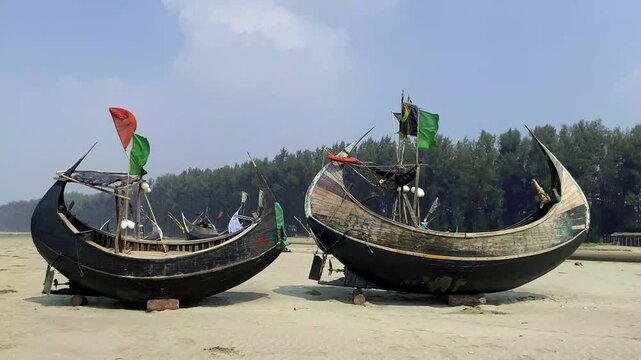 Traditional fishing boat anchored on the sandy shores of Cox's Bazar beach, Cox's Bazar sea beach is the longest sea beach in the world. Fishing boat at the Cox's Bazar sea beach in Bangladesh