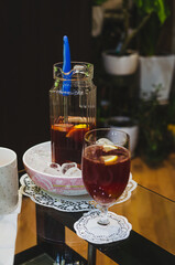 Refreshing peach punch served with ice and lemon slices. Beverage presentation, cozy mood, medium-close shot, tabletop view, indoor setting, focus on glassware, refreshing drink and leisure concept.