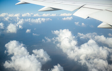 Fototapeta na wymiar Aerial view of white clouds and the land below. Airplane flying towards Shanghai. China.