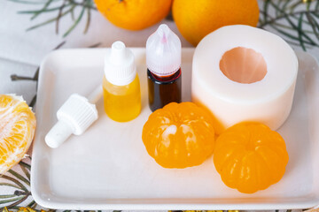 Handmade soap in the form of a tangerine with bottles of dye, flavor, a block of glycerin soap base, silicone mold, pipette. Soap as a gift, home-made