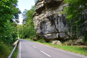 country road through the Mullerthal in Luxembourg with the cliffs, straight