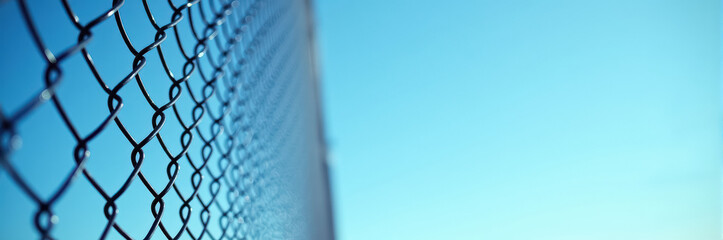 Fototapeta premium Metal mesh fence against clear sky