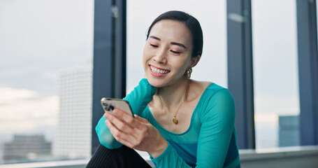 Phone, happy and Japanese woman in dance studio with networking, communication or browsing social media. Smile, cellphone and female ballerina watching online video for classic technique at rehearsal