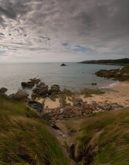 Coastal View: Rocky Shoreline, Sandy Beach, and Island