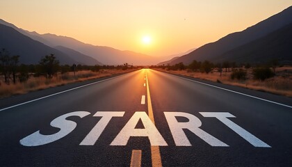 Highway leads to the mountains landscape view with the white text 'START' painted on the asphalt against sunrise sky