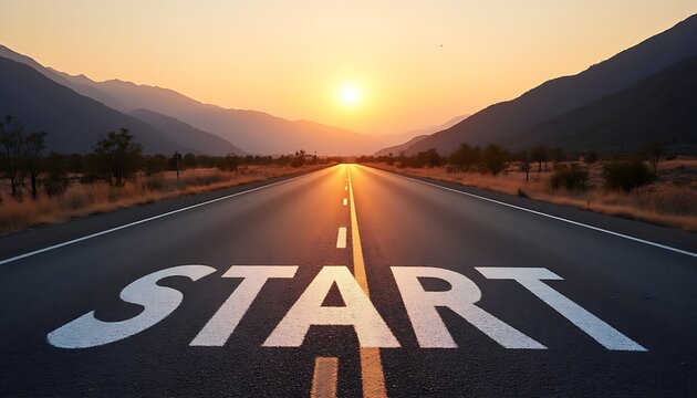 Highway leads to the mountains landscape view with the white text 'START' painted on the asphalt against sunrise sky