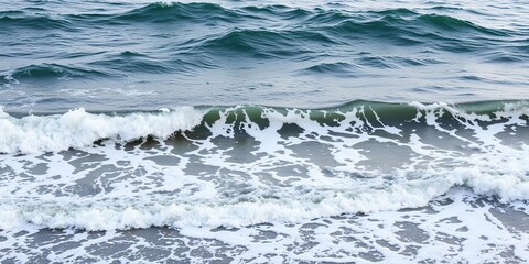 Fototapeta premium Waves gently lapping at the shore in a dramatic coastal scenery, natural elements, soothing colors, calm waters