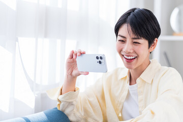 スマホを使う若い女性。
