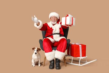 Santa Claus with cute Jack Russell Terrier dog and Christmas gift boxes on brown background