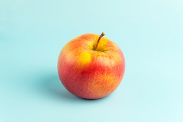 ripe red apple on a blue background