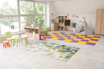 Interior of kindergarten with toys, play tent and table