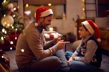Happy father and son communicating while spending Christmas Eve at home.