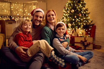 Portrait of happy family on Christmas Eve at home looking at camera.