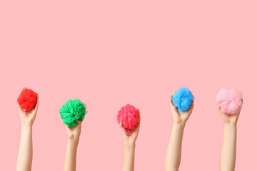 Female hands with different bath sponges on pink background