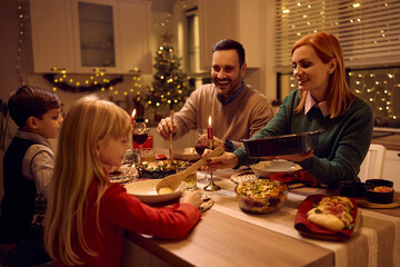 Happy family eating Christmas dinner at dining table.