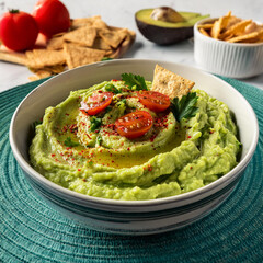Vibrant Avocado Hummus with Fresh Ingredients and Crackers