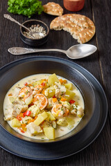 seafood chowder in a white bowl, top view