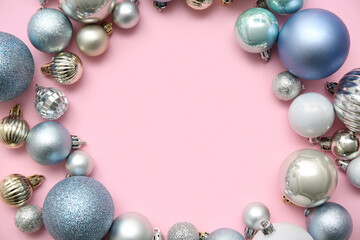 Frame made of Christmas balls on pink background