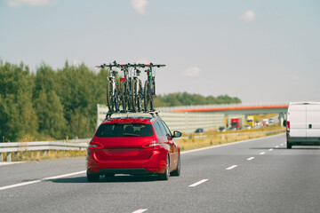 Red vehicle transporting bicycles on highway