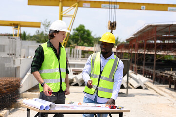 Engineers and foremen wearing hard hats in factory. Hard hats talking on construction site.