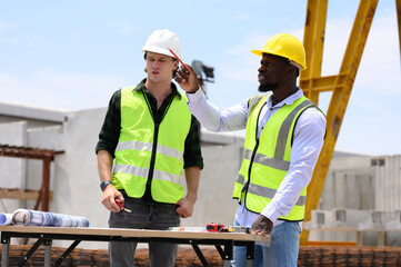Engineers and foremen wearing hard hats in factory. Hard hats talking on construction site.