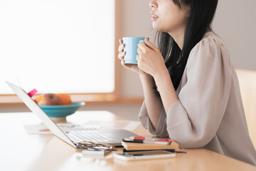 在宅での仕事中に休憩する女性