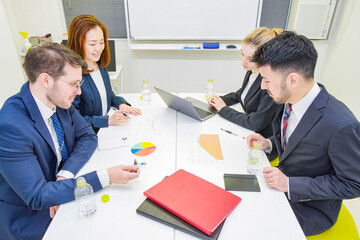 会議室で話し合いをするビジネスパーソン